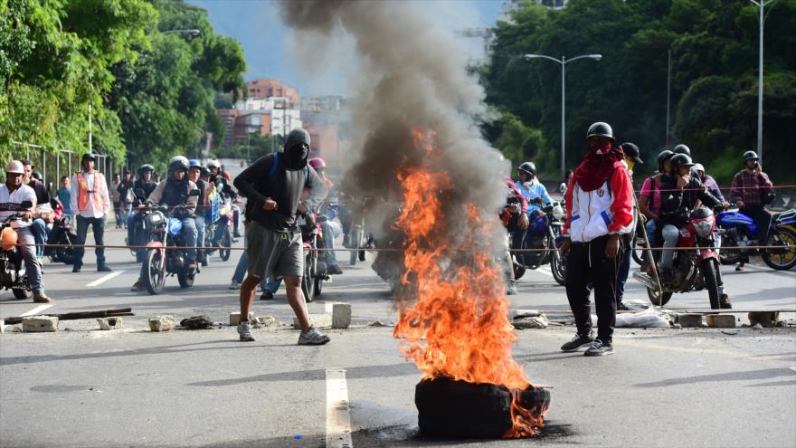 Manifestantes opositores bloquean una avenida de Caracas durante una protesta antigubernamental en la jornada del paro general, 20 de julio de 2017.