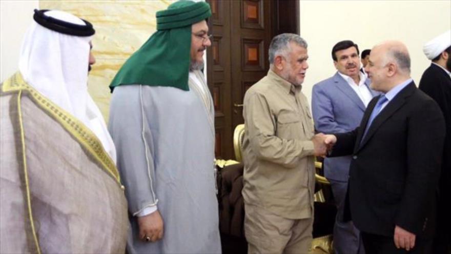 El premier iraquí, Haidar al-Abadi (dcha.), y el jefe de la organización Badr, Hadi al-Ameri, se estrechan la mano en Bagdad, 22 de julio de 2017.