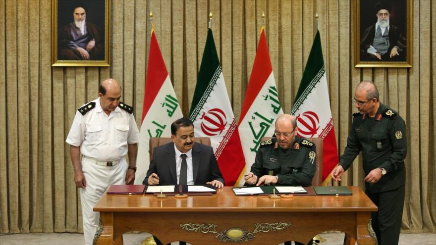 Ministro de Defensa iraní, Husein Dehqan (dcha.), y su homólogo iraquí, Erfan al-Hiyali, firman acuerdo para cooperación militar, 23 de julio de 2017.