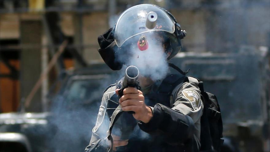 Un soldado israelí dispara gas lacrimógeno contra manifestantes en los territorios ocupados palestinos, 24 de julio de 2017.