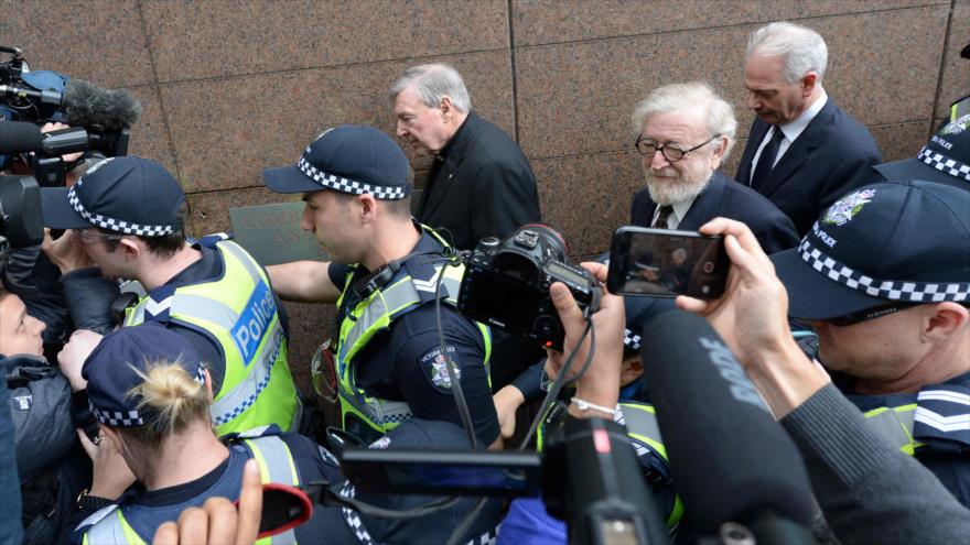 El cardenal George Pell, escoltado por policías australianos tras la audiencia preliminar del tribunal de Melbourne, 26 de julio de 2017. 