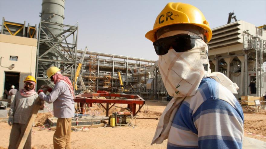 Un trabajador observa a los periodistas durante una gira de prensa por el campo petrolífero de Khurais, a unos 160 kilómetros de Riad, capital saudí.