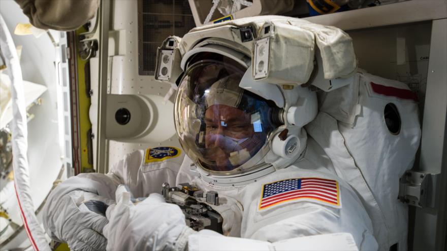El comandante Scott Kelly prueba su traje dentro de la cámara de aire de la Estación Espacial Internacional antes de una caminata espacial.