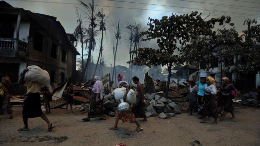 Residentes musulmanes de Sittwe, la capital del estado birmano de Rajine, abandonan sus casas tras un violento ataque de budistas, junio de 2012.