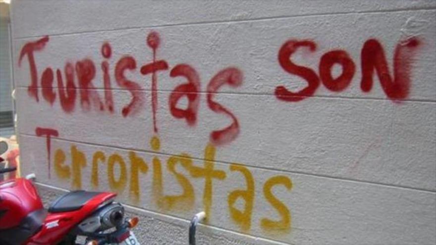 Una pintada equipara turistas a terroristas en la ciudad de Barcelona (noreste de España) en el verano boreal de 2017.