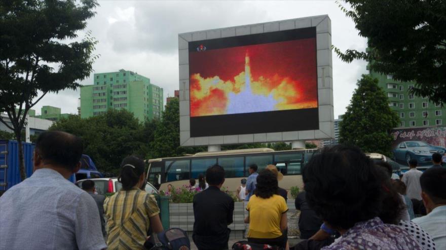 Norcoreanos ven la prueba de un misil balístico intercontinental en una pantalla en una plaza pública en Pyongyang, 29 de julio de 2017.