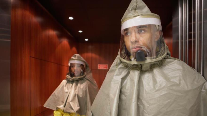 Dos ciudadanos británicos visten ropa especial para evitar radiaciones nucleares en un simulacro de ataque nuclear.