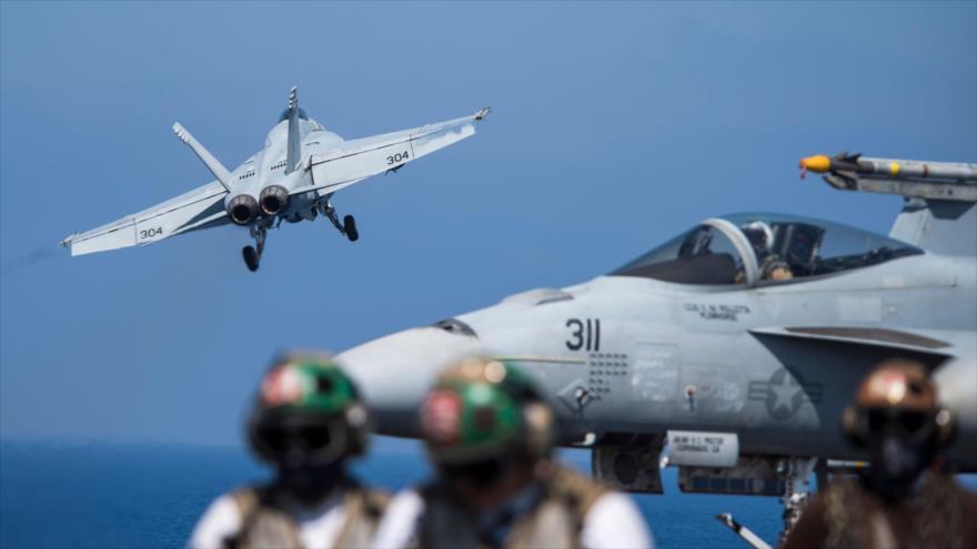 Caza de combate de EE.UU. bajo mando de la coalición anti-EIIL despega de un portaaviones estadounidense cerca de las costas de Siria.