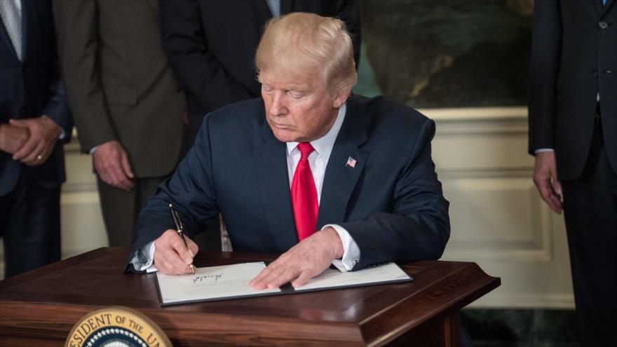 El presidente de EE.UU., Donald Trump, firma un memorándum que autoriza investigar sobre China por casos de propiedad intelectual, 14 de agosto de 2017.