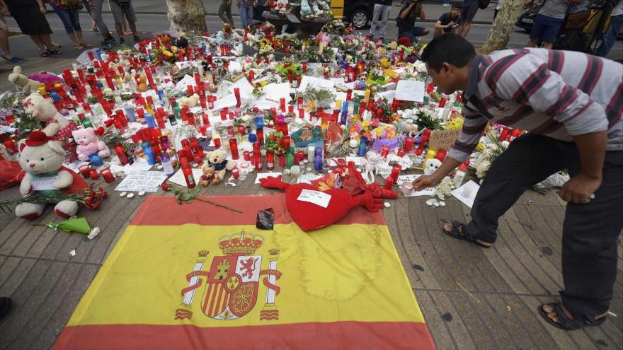 Un hombre coloca una vela para rendir homenaje a las víctimas del ataque de Barcelona en la calle de La Rambla en Barcelona, 19 de agosto de 2017.