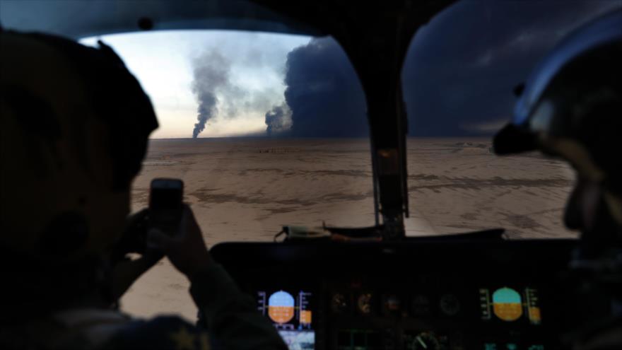 Un piloto de la Fuerza Aérea iraquí toma fotos de los pozos de petróleo incendiados por Daesh en Qayyarah, al sur de Mosul, 25 de noviembre de 2016.
