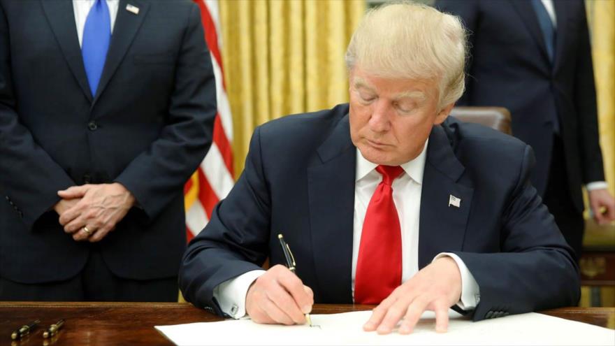 El presidente de EEUU, Donald Trump, firma una orden ejecutiva en el Despacho Oval, en la Casa Blanca.