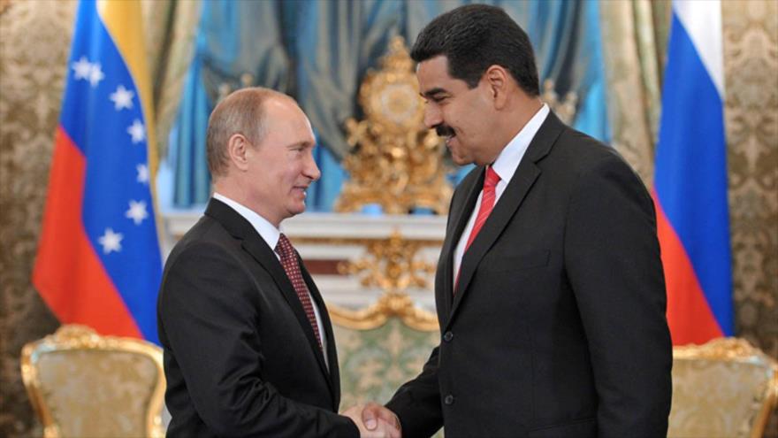 El presidente venezolano, Nicolás Maduro (dcha.), y su par ruso, Vladimir Putin, se dan la mano durante una reunión en Moscú (capital rusa).