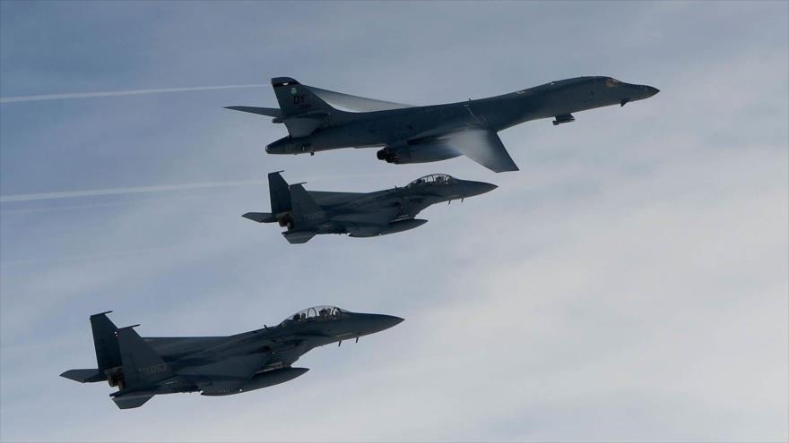 Dos cazabombarderos F-15K Slam Eagle surcoreanos junto con un bombardero nuclear B-1B Lancer de Estados Unidos.