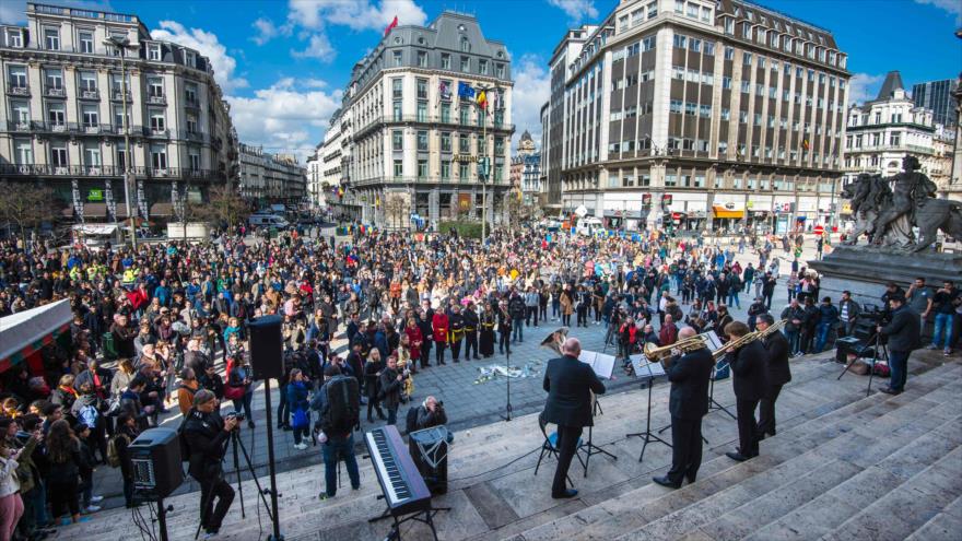 La gente se reúne para rendir homenaje a las víctimas de los atentados terroristas de 2016 en la plaza bursátil, en Bruselas, 22 de marzo de 2017.
