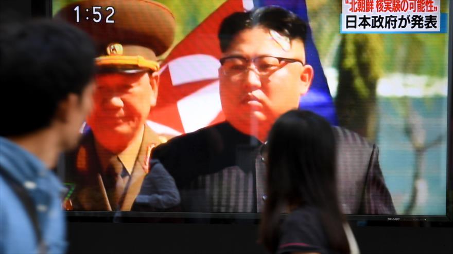 Peatones japoneses pasan por una pantalla de televisión que transmite un programa de noticias sobre el ensayo nuclear norcoreano, Tokio, 3 de septiembre de 2017.