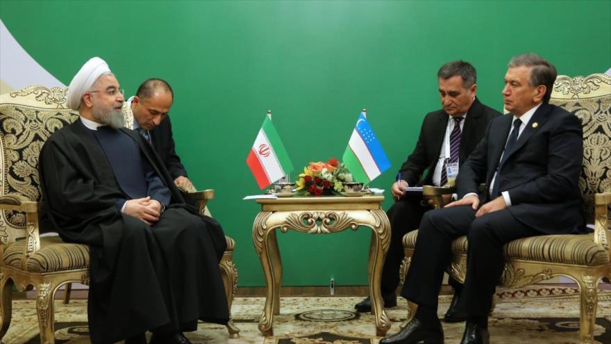 El presidente iraní, Hasan Rohani (izda.), se reúne con su par de Uzbekistán, Shavkat Mirziyoyev, en Astaná (capital kazaja), 10 de septiembre de 2017.
