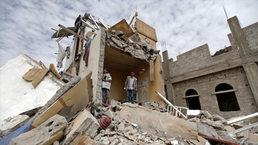 Los yemeníes en pie sobre los escombros de una casa destruida por los ataques de Arabia Saudí en Saná, capital yemení, 25 de agosto de 2017.