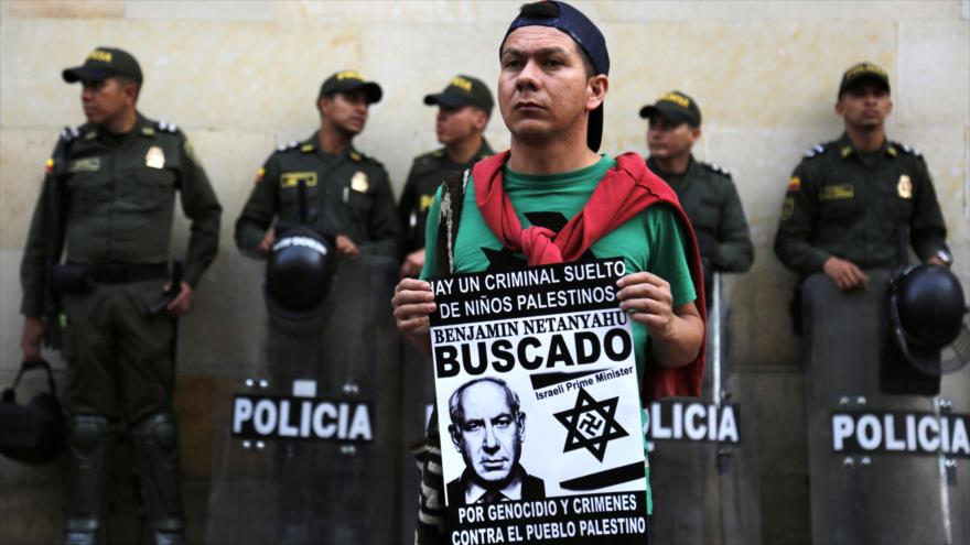 Colombiano sostiene un cartel con el lema “Benyamin Netanyahu: Buscado” en una protesta contra la visita del premier israelí, 13 de septiembre de 2017.