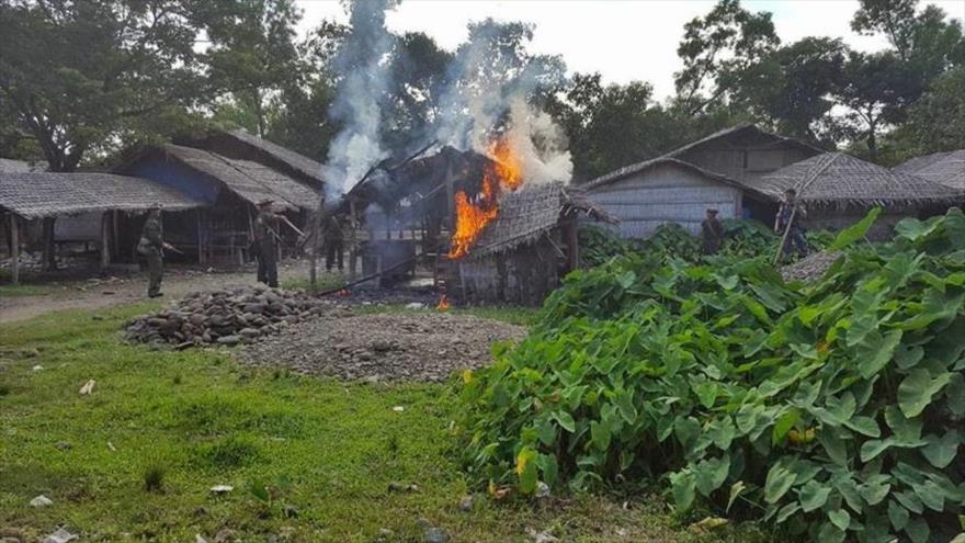 Soldados birmanos prenden fuego a una casa de los musulmanes rohingyas en Rajine.