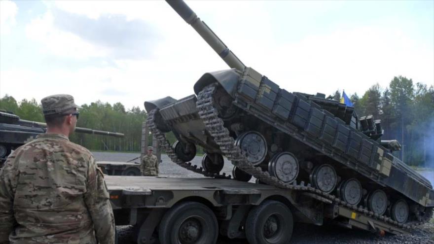 Un soldado estadounidense observa el descargue de un tanque del Ejército de Ucrania.