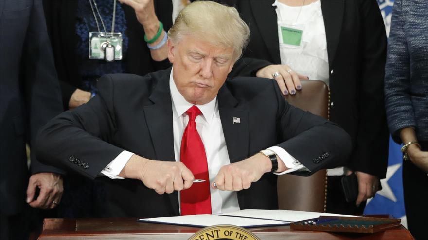 El presidente de EE.UU., Donald Trump, firma una orden ejecutiva durante su visita al Departamento de Seguridad Nacional, 25 de enero de 2017.