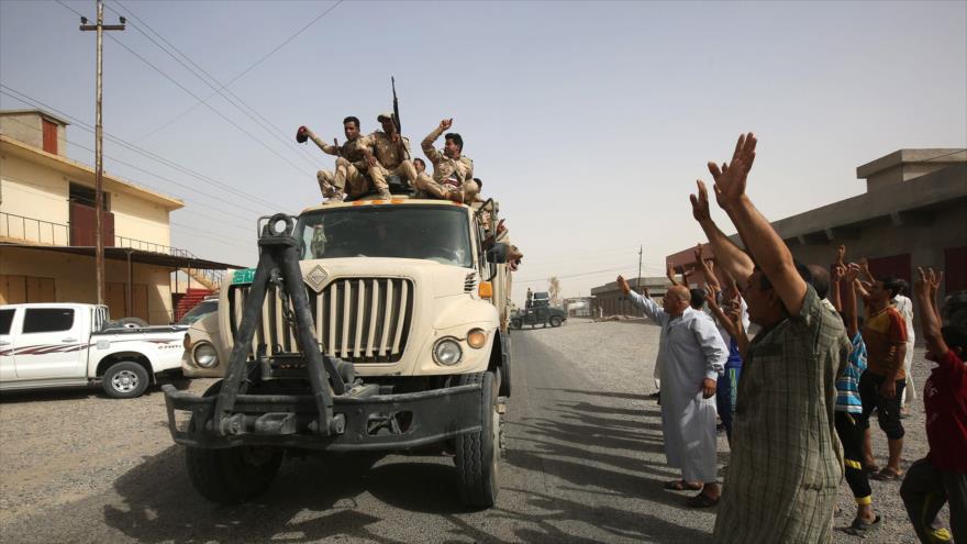 Las familias iraquíes en Al-Shirqat saludan a las fuerzas iraquíes mientras el Ejército avanza para expulsar a EIIL de Al-Hawija, 23 de septiembre de 2017.