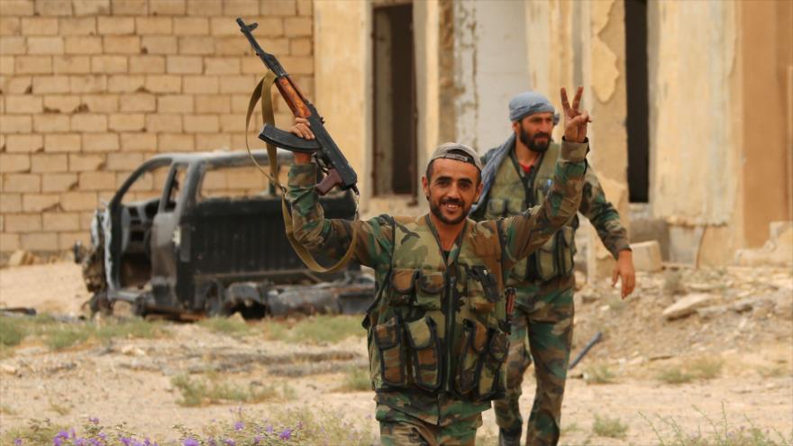 Fuerzas progubernamentales sirias hacen el gesto de la victoria desde las afueras de Deir Ezzor, 24 de septiembre de 2017.