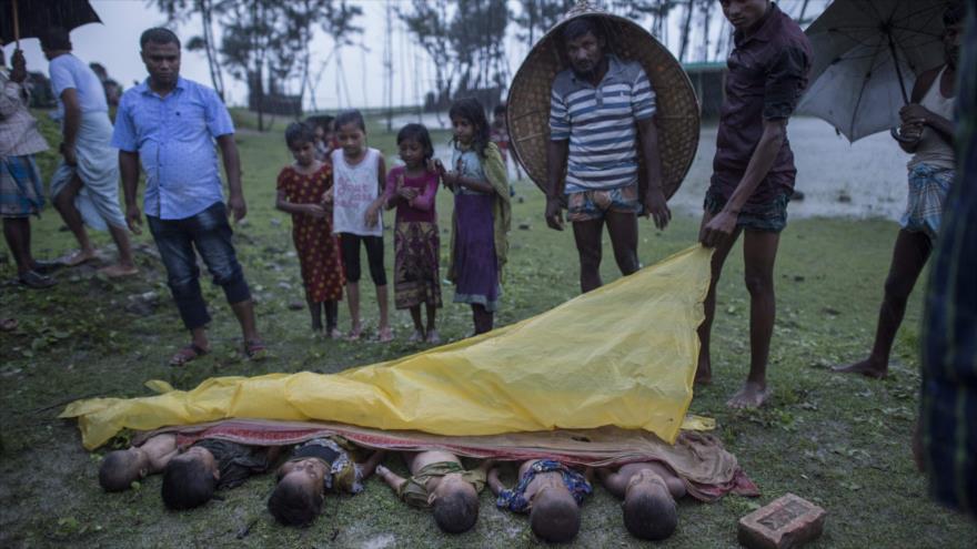Gente reunida alrededor de los cuerpos sin vida de niños rohingyas cerca de la orilla de la playa bangladesí Inani, 28 de septiembre de 2017.
