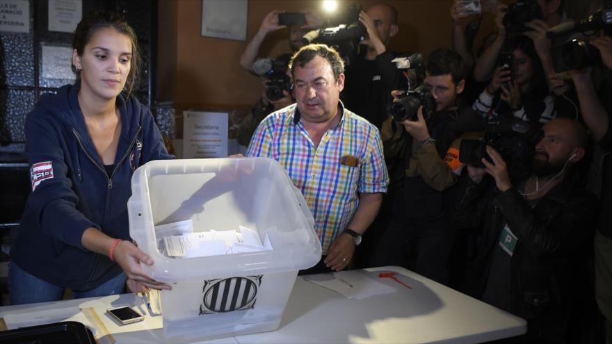 Una mujer abre una urna en una mesa de votación en Barcelona para contar los votos del referéndum independentista, 1 de octubre de 2017.
