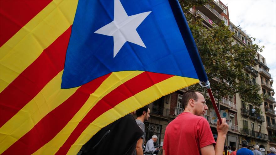 Un hombre ondea bandera no oficial de independentistas catalanes (Estelada) durante una marcha en Barcelona celebrada el 3 de octubre de 2017.