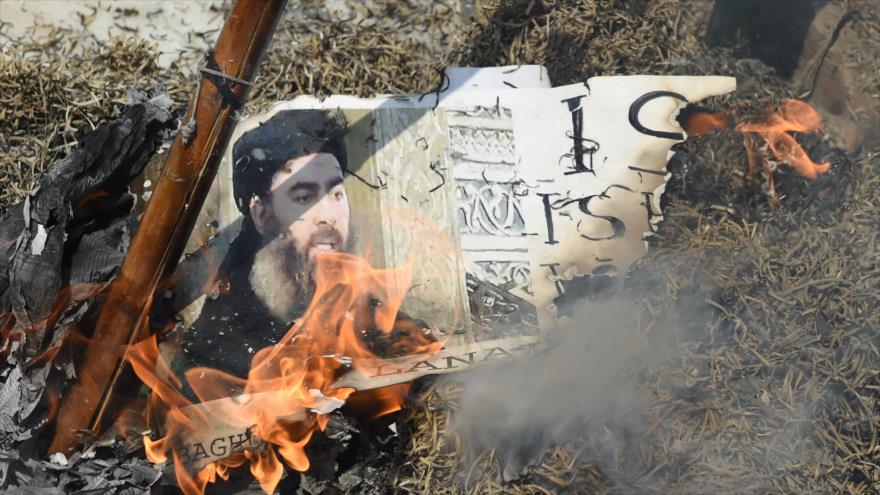Una imagen del líder de Daesh, Abu Bakr al-Bagdadi, se quema en el fuego, 9 de junio de 2017.