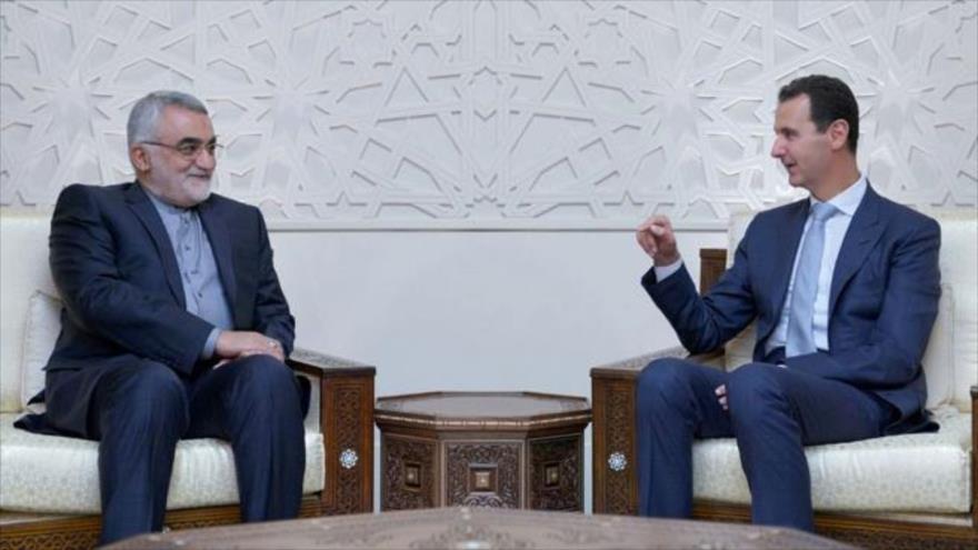 Bashar al-Asad (dcha.), presidente de Siria, habla con el parlamentario iraní Alaeddin Boruyerdi en Damasco (capital siria), 5 de octubre de 2017.