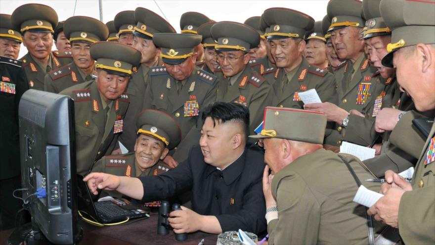 El líder de Corea del Norte, Kim Jong-un, rodeado de militares, revisa un ordenador.