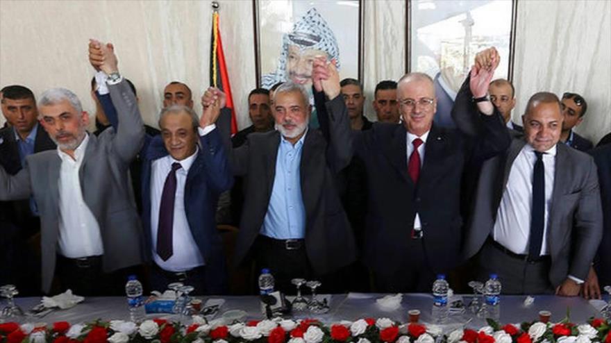 Las autoridades palestinas y un mediador egipcio sostienen sus manos durante una reunión en la ciudad de Gaza, 2 de octubre de 2017.