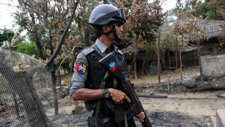 Un militar birmano vigila cerca de una casa que fue incendiada en Maungdaw, en el estado de Rajine (oeste de Myanmar).