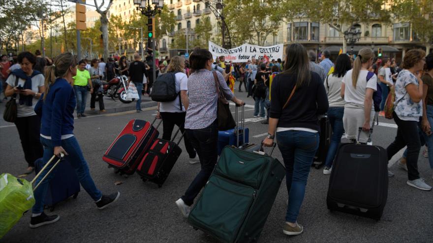 Varios turistas extranjeros observan una manifestación convocada por los trabajadores en Barcelona, 3 de octubre de 2017.