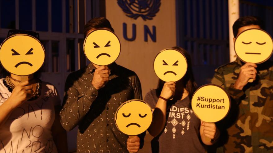 Activistas kurdos, reunidos ante oficina de la ONU en Erbil, portan emoji triste frente de sus caras para mostrar su preocupación ante la crisis en Kurdistán iraquí, 17 de octubre de 2017.