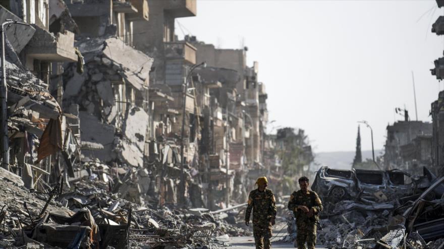 Integrantes de las llamadas Fuerzas Democráticas Sirias (FDS) entre los escombros en Al-Raqa (norte de Siria), 20 de octubre de 2017.