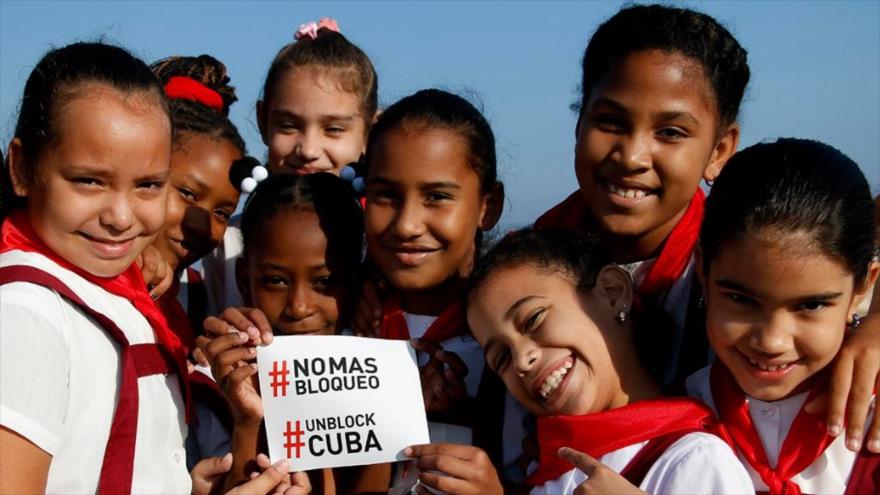 Niños cubanos muestran su descontento por el bloqueo de EE.UU. contra su país.