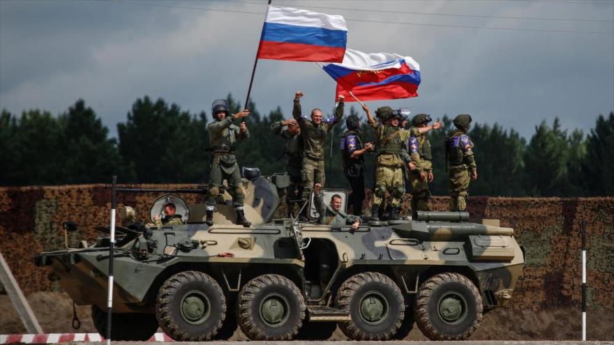 Soldados rusos sostienen su bandera nacional en un desfile militar.