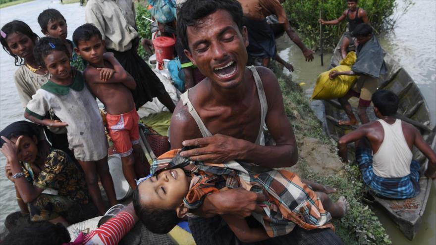 Un refugiado rohingya reacciona mientras sostiene a su hijo muerto después de cruzar el río Naf para escapar de Myanmar a Bangladesh, 9 de octubre de 2017.