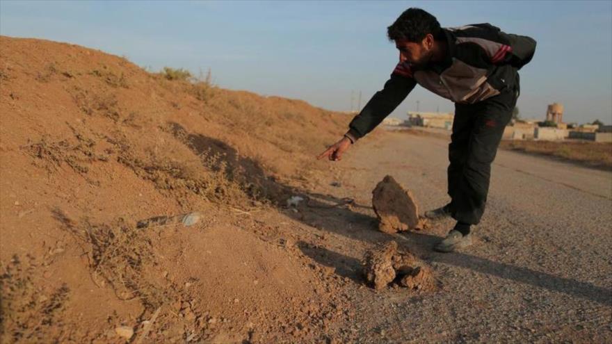 Un civil apunta a una mina colocada por el grupo terrorista EIIL (Daesh, en árabe) en aldea siria de al-Heesha, en el norte de Al-Raqa.