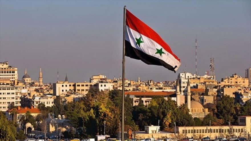 Bandera nacional siria izada en un barrio de Damasco, la capital del país árabe.