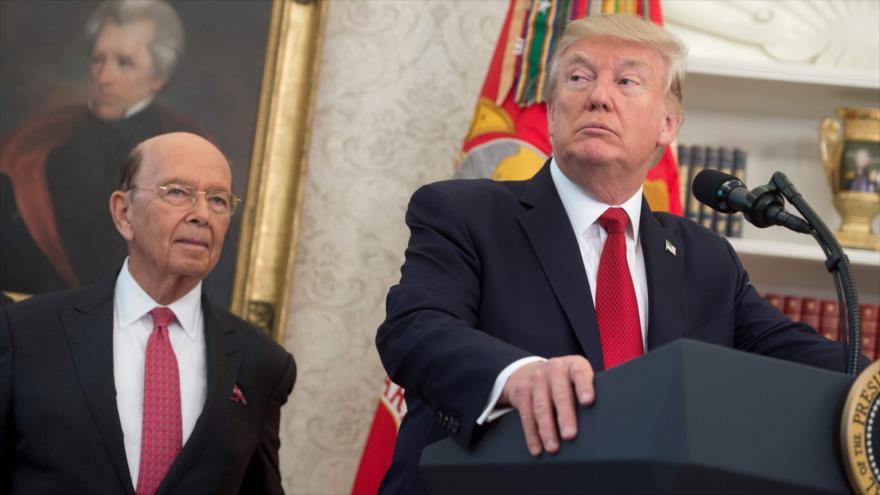 El secretario de Comercio de EE.UU., Wilbur Ross, está al lado del presidente Donald Trump, durante una rueda de prensa, 24 de octubre de 2017.