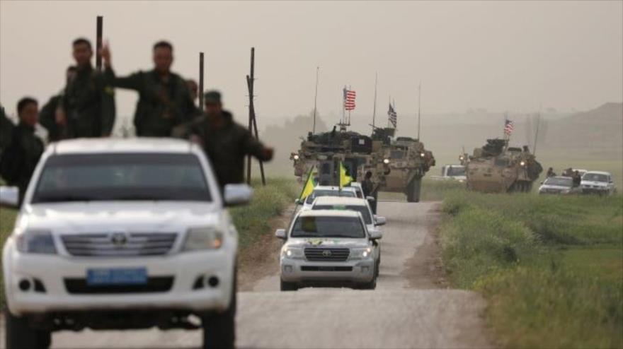Las milicias kurdas YPG encabezan un convoy de vehículos militares estadounidenses en la ciudad de Darbasiya, cerca de la frontera turco-siria, 28 de abril de 2017.