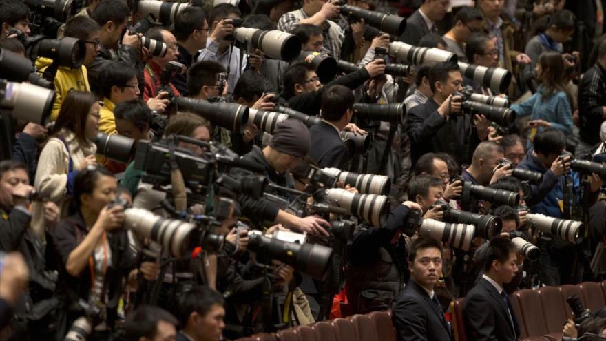 Periodistas chinos cubren un evento.