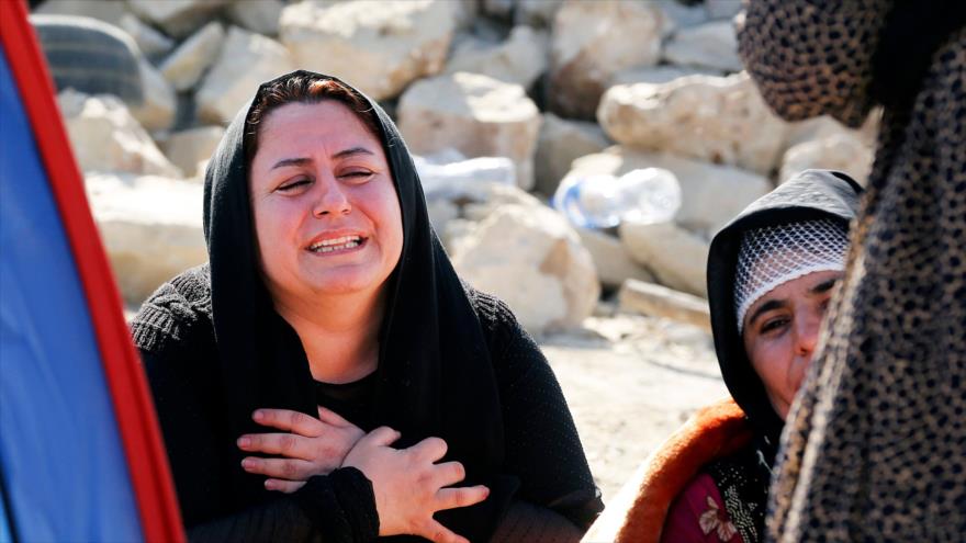 Iraníes enlutados junto a los escombros de su hogar en la aldea Kouik tras el terremoto que azotó el oeste de Irán, 15 de noviembre de 2017.