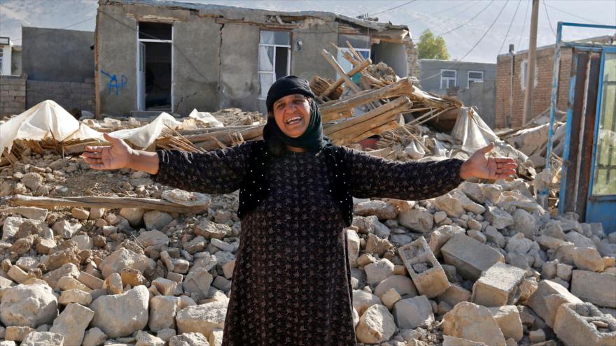 Una iraní enlutada junto a escombros de su hogar en la aldea Kouik, cerca de Sarpol-e Zahab, ciudad más afectada por el sismo, 15 de noviembre de 2017.