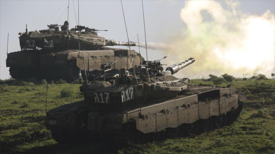 Tanques israelíes modelo Merkava Mark IV realizan disparos en unas maniobras en los altos de Golán sirios.